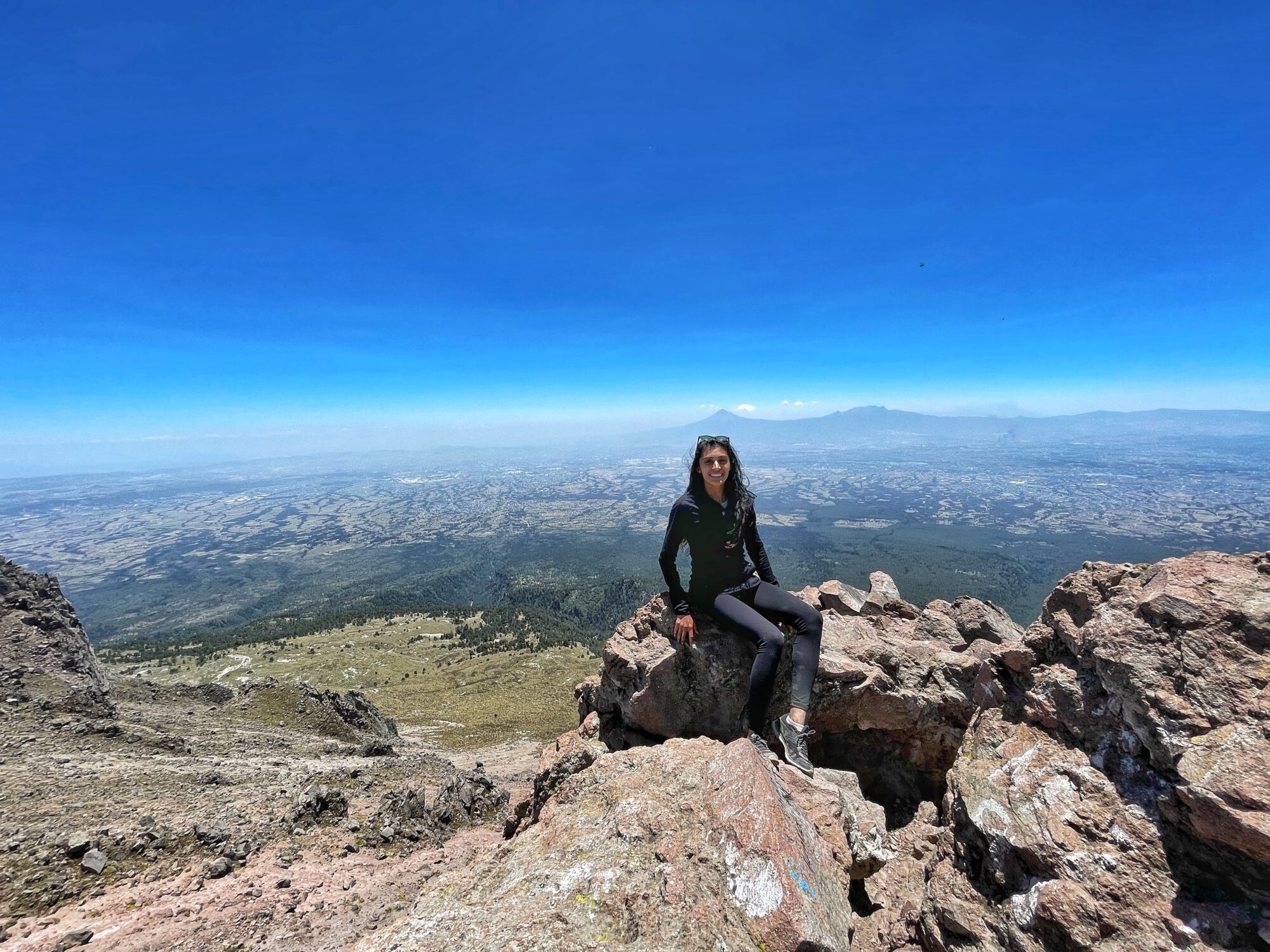 Shreya sitting on a rock on the summit of La Malinche